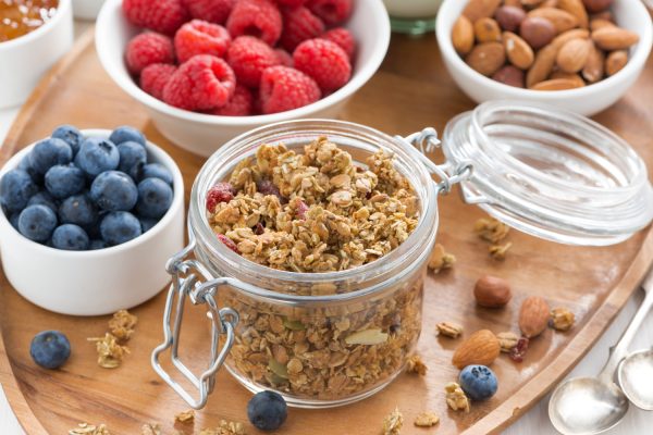 Müsli i glas med små skåle med friske blåbår og hindbær