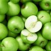 Grønne syrlige granny smith æbler fylder hele baggrunden og et enkel æble et skrået i halve