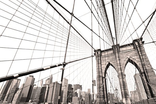 Brooklyn Bridge i New York City. Billedet er taget nedefra og er i grålige nuancer