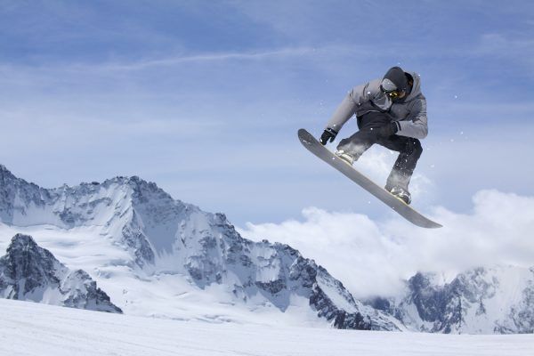 Snowboarder der hænger i luften i det smukke sneklædte landskab