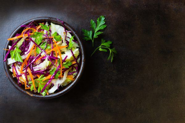 Asiatisk salat i skål set oppe fra på sort bord