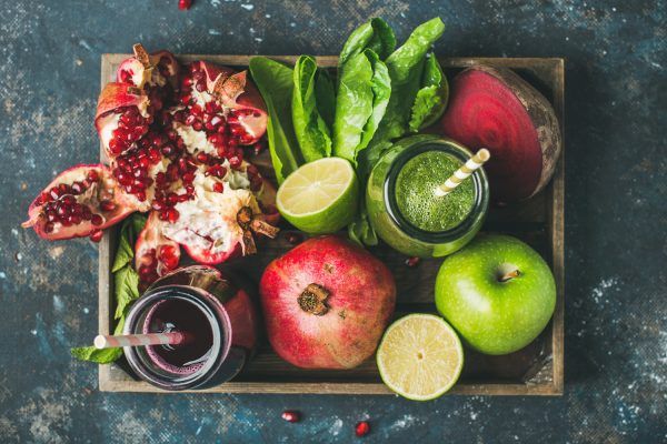 Bakke med granatæble, rødbede, lime, æble og salat. På bakken ses også smootie og juice.