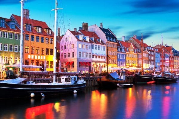 Nyhavn med blikstille vand overflade, farver der genspejler sig i vandet